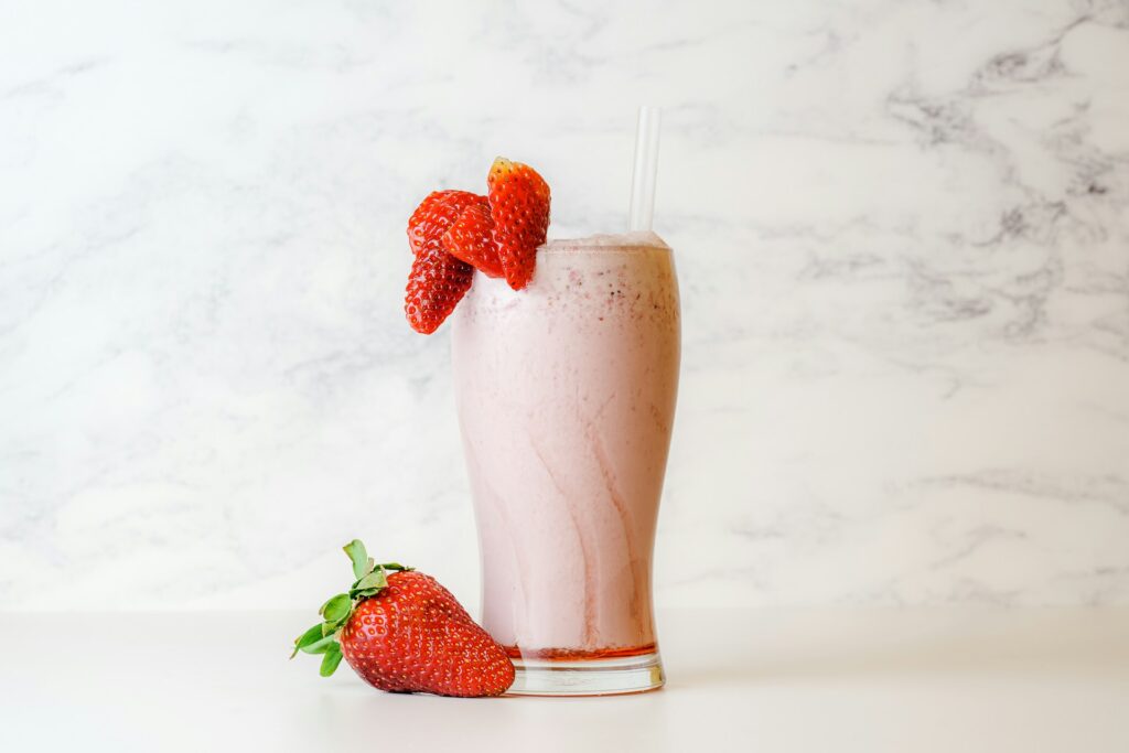 Strawberry oat milk in a glass garnished with strawberries