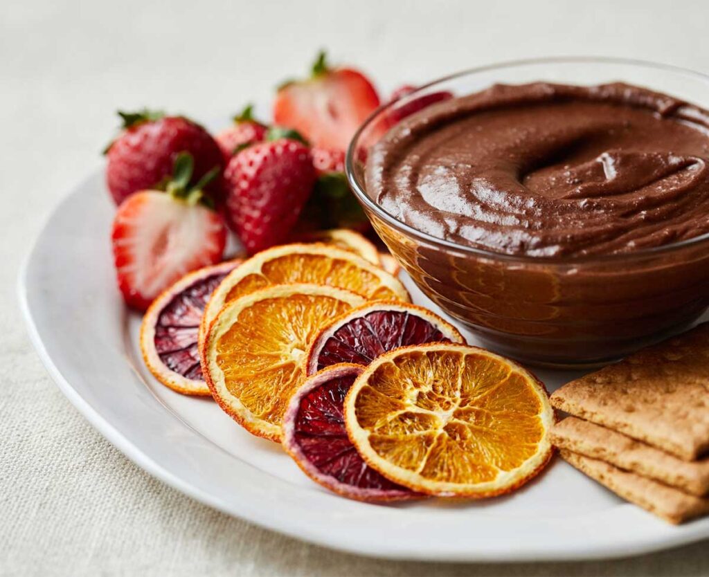 Chocolate dessert hummus with strawberries and vegan graham crackers.